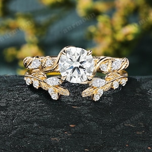 Conjunto de anéis de noivado femininos com diamantes sintéticos de lapidação redonda, design vintage em ouro amarelo 10K com folhas e galhos, aliança aberta e curva.