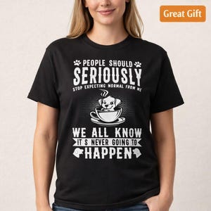 May include: Black t-shirt with white text and a graphic of a dog in a teacup. The text reads "PEOPLE SHOULD SERIOUSLY STOP EXPECTING NORMAL FROM ME" and "WE ALL KNOW IT'S NEVER GOING TO HAPPEN."
