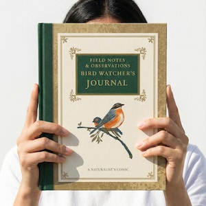 May include: A hardcover journal with the title "Field Notes & Observations Bird Watcher's Journal" and a watercolor illustration of two birds on a branch. The journal has a green spine and a gold-colored border.