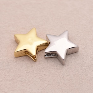 May include: Two star-shaped beads. One is gold-colored and the other is silver-colored. The beads have a smooth, metallic finish and are designed with five points. They are likely used for jewelry making or other craft projects.
