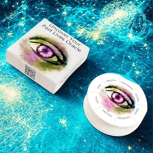 Puede incluir: Una baraja de cartas "Uncover Your Past Lives Oracle". La caja y las cartas presentan un diseño de ojo con un reloj púrpura en el centro. El fondo es de color verde azulado con un diseño de explosión estelar.
