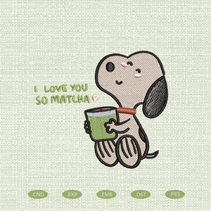 May include: An embroidery design featuring a light brown cartoon dog with a black ear, holding a green cup. The text "I LOVE YOU SO MATCHA" is embroidered in green next to the dog. The design includes small pink accents on the cheeks and a red dot.