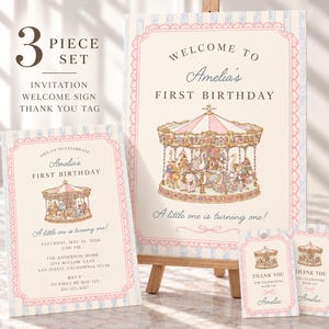 May include: A three-piece set featuring a welcome sign, invitation, and thank you tags with a carousel illustration. The stationery has a cream background, light blue striped borders, and pink scalloped frames with text for Amelia's first birthday.
