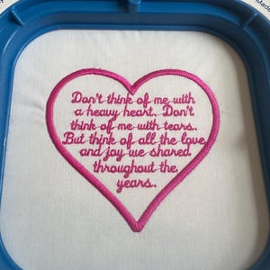 Op de afbeelding: Geborduurd hartvormig ontwerp met de tekst "Denk niet aan mij met een zwaar hart. Denk niet aan mij met tranen. Maar denk aan al de liefde en vreugde die we in de loop der jaren hebben gedeeld."