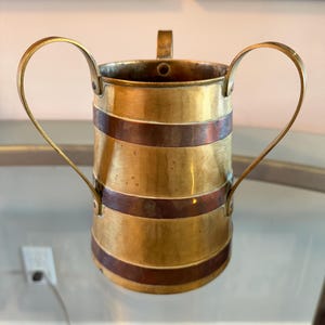 May include: A set of three ceramic mugs with a speckled, matte finish. The mugs are in shades of cream, light gray, and dark gray. Each mug has a simple, minimalist design, perfect for coffee or tea.