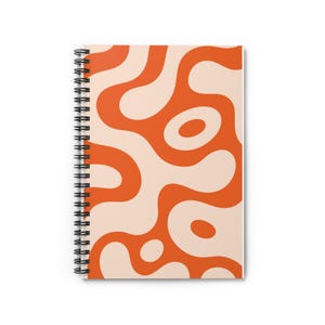 Puede incluir: Un cuaderno de espiral con un patrón repetitivo de formas fluidas y orgánicas en naranja vibrante y crema suave. La encuadernación de alambre metálico negro recorre el lado izquierdo, asegurando la portada que muestra el diseño abstracto.