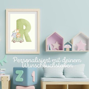 Könnte beinhalten: Ein gerahmter Druck mit einem großen grünen Buchstaben "R" und einer Aquarellillustration von Safaritieren in einem grünen Fahrzeug. Der Druck befindet sich in einem hellen Holzrahmen an einer hellblauen Wand.
