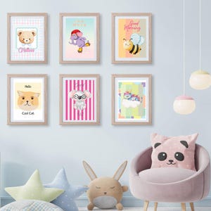 Könnte beinhalten: Eine Sammlung gerahmter Kinderkunstdrucke mit niedlichen Tierillustrationen, darunter ein Bär, ein Elefant, eine Biene, eine Katze, ein Koala und ein Einhorn. Die Drucke werden an einer hellblauen Wand mit dekorativen Kissen und einem Stuhl ausgestellt.
