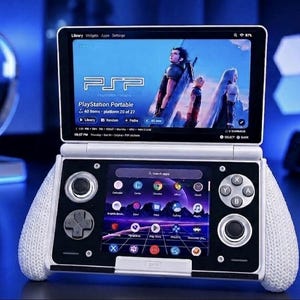 May include: A dual-screen handheld gaming console with a white frame and textured white side grips. The top screen displays a PlayStation Portable library interface with character art, while the bottom screen shows a grid of app icons and a search bar.