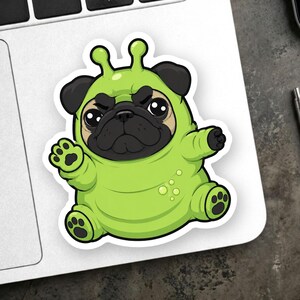 May include: A die-cut sticker featuring a cartoon pug dog wearing a bright lime green alien costume with two antennae on its head. The pug has a grumpy facial expression, black ears, and black paws. The costume includes small circular details.