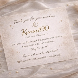 May include: A cream-colored card with gold text that reads "Thank you for your purchase" and "Kunus890 Women's Sleepwear." The card is decorated with small stars and a crescent moon. A small perfume bottle and a pearl necklace are also visible.