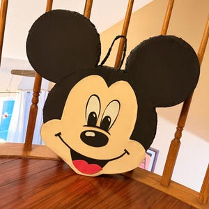 May include: A white ceramic mug with a black handle and the text "But First, Coffee" in a handwritten style. The mug is on a white surface. The mug is 4 inches tall.