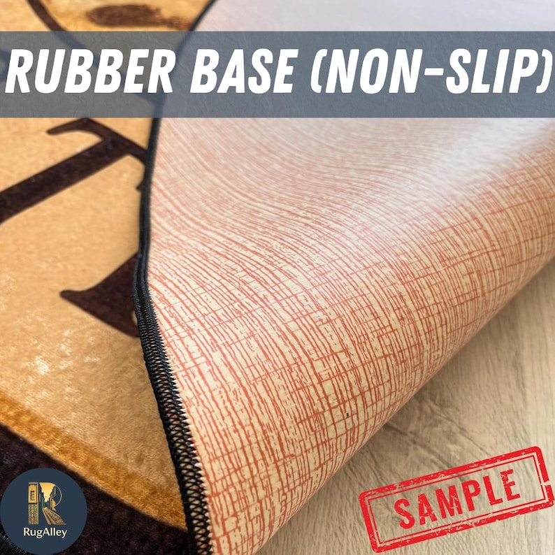 Puede incluir: Primer plano de la parte inferior de una alfombra, que muestra una base de goma antideslizante con un patr&oacute;n texturizado marr&oacute;n rojizo. El borde de la alfombra es visible, con un borde cosido negro. El texto "RUBBER BASE (NON-SLIP)" est&aacute; visible.
