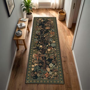 May include: A long, rectangular rug with a dark background and a detailed floral pattern. The rug has a border with a repeating star design. The colour palette includes shades of green, brown, and cream, creating a natural, botanical theme.