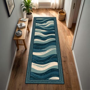 May include: A rectangular runner rug with a wave pattern in shades of blue and off-white. The rug has a dark blue border with a rope-like design. The rug is placed on a wooden floor in a hallway.