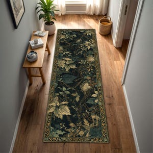 May include: A long, rectangular rug with a dark background and a botanical design. The rug features a pattern of green and beige leaves, branches, and vines. The border has a gold and green floral design. The rug is placed in a hallway with wooden floors.