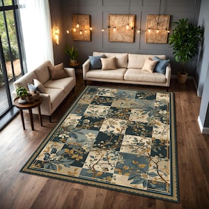 Op de afbeelding: Een groot vloerkleed met een bloemenpatroon in blauw, beige en goud. Het vloerkleed heeft een dambordpatroon met botanische elementen, waaronder bloemen en takken. Het vloerkleed ligt op een houten vloer in een woonkamer.