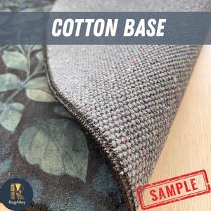 Puede incluir: Primer plano del reverso de una alfombra, que revela una base de algod&oacute;n gris. El borde de la alfombra es visible, con un patr&oacute;n floral oscuro en la parte superior. El texto "COTTON BASE" se muestra en la parte superior y un sello "SAMPLE" est&aacute; en la esquina.