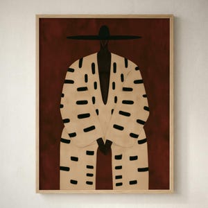 Può includere: Una stampa artistica incorniciata raffigurante una figura stilizzata che indossa un cappello nero a tesa larga e una veste beige decorata con motivi a trattini neri orizzontali. La figura è su uno sfondo rosso scuro uniforme in una cornice di legno chiaro.
