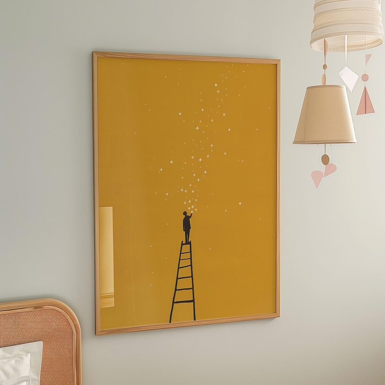 May include: A framed art print featuring a silhouette of a person on a ladder reaching for stars against a mustard yellow background. The artwork has a minimalist style with a wooden frame, suitable for home decor.
