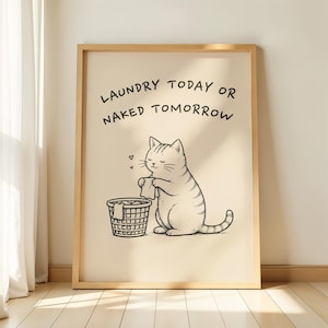 Könnte beinhalten: Ein gerahmter Kunstdruck mit einer schwarzen Strichzeichnung einer getigerten Katze, die ein Kleidungsstück über einem Wäschekorb hält. Der Text über der Katze lautet LAUNDRY TODAY OR NAKED TOMORROW in einer einfachen schwarzen Schrift auf beigem Grund.