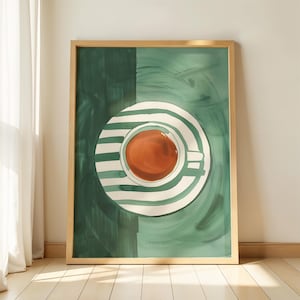 Könnte beinhalten: Ein gerahmter Wandkunstdruck mit einer Draufsicht auf eine Teetasse mit bernsteinfarbener Flüssigkeit, die auf einer Untertasse mit weißen und dunkelgrünen Streifen steht. Der Hintergrund ist in zwei Grüntöne mit sichtbaren Pinselstrichen unterteilt.