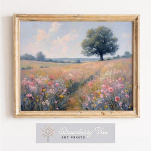 May include: A framed landscape art print featuring a field of wildflowers in shades of pink, yellow, and purple, with a path leading to a large tree. The sky is a soft blue with fluffy clouds. The frame is gold, and the print includes the text "Strawberry Tree ART PRINTS".