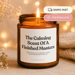 Può includere: Una candela accesa in un barattolo di vetro ambrato con un'etichetta bianca che riporta il testo nero: The Calming Scent Of A Finished Masters. Notes of two years of lectures and a thesis that nearly broke you. Rose House Co. è scritto sotto.