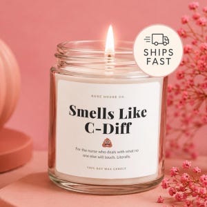 Op de afbeelding: Een kaars in een doorzichtige glazen pot met een wit etiket met de zwarte tekst Smells Like C-Diff, een kleine bruine poep-emoji en de ondertitel For the nurse who deals with what no one else will touch. Literally. De kaars heeft een brandende lont.