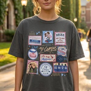 May include: A charcoal grey short-sleeve t-shirt featuring a collage of rectangular and circular graphic prints. The designs include illustrations of a couple, a cake, a bottle, and text reading Briar University, Off Campus, and Malene.