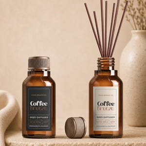 May include: Two amber glass bottles for a reed diffuser, each featuring a label that reads Coffee Breeze, Reed Diffuser, Your Brand Co., and Handmade in Colorado. One bottle is capped, while the other is open with several dark brown reeds inserted.
