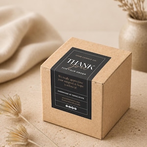 May include: A square cardboard box with a black rectangular label featuring the text: YOUR CANDLE CO. THANK YOU FOR YOUR ORDER. We really appreciate your support & hope you love it! HANDMADE IN TOWN | STATE yourwebsitehere.com @yoursocialhandle.