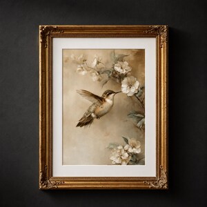 Peut inclure: Impression d'art encadrée avec un colibri et des fleurs blanches. L'œuvre a une esthétique vintage, avec un cadre doré orné et un fond sépia. Le colibri est représenté avec des plumes détaillées et un long bec.