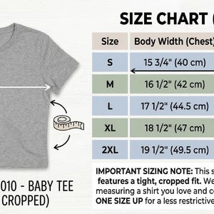 May include: A grey Bella+Canvas 1010 baby tee, slim fit and cropped, with a size chart showing body width and length measurements in cm. Sizes range from S to 2XL, with body widths from 40 cm to 49.5 cm. The tee is designed for a tight, cropped fit.