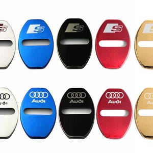 Puede incluir: Una colección de diez cubiertas para cerraduras de puertas de automóviles en varios colores, incluyendo blanco, azul, negro, rojo y dorado. Cada cubierta presenta el logotipo de Audi o el logotipo S, con una abertura rectangular en el centro.