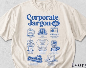 May include: Ivory-colored t-shirt with the words "Corporate Jargon" in blue, along with various illustrations and phrases like "Thought Leadership" and "Touch Base." The shirt features a humorous design with business-related jargon.
