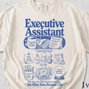 Könnte beinhalten: Ein elfenbeinfarbenes T-Shirt mit blauen grafischen Texten und Illustrationen. Das Design zeigt die Worte Executive Assistant, eine Kaffeetasse, ein Telefon, eine Checkliste, einen Oktopus beim Multitasking, einen Computer und eine Kristallkugel mit verschiedenen Sprüchen.