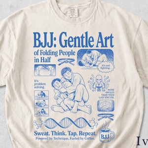 Op de afbeelding: Ivoor kleurig t-shirt met een blauw grafisch ontwerp. Het ontwerp bevat de tekst "BJJ: Gentle Art of Folding People in Half" en illustraties gerelateerd aan Jiu-Jitsu. De tekst "Sweat. Think. Tap. Repeat." is ook aanwezig.