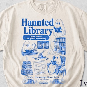 Könnte beinhalten: Ein elfenbeinfarbenes T-Shirt mit blauem Grafikdruck und dem Text Haunted Library, Quiet, Please. The spirits are reading., Shhh... Knowledge Never Dies. (It just lingers.). Das Design zeigt lesende Geister, eine Bibliothekskarte und Bücherstapel.