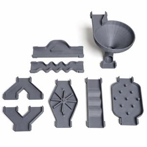 May include: A collection of gray plastic marble run components, including a funnel, wavy tracks, and various directional pieces. The pieces are designed to connect and create a marble run. The components are shown against a white background.