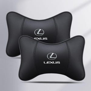 Könnte beinhalten: Zwei schwarze Kopfstützen für Autos mit dem silbernen Lexus-Logo. Die Kissen haben eine konturierte Form und bestehen aus einem glatten, lederartigen Material. Das Lexus-Logo ist auf jedem Kissen zentriert.