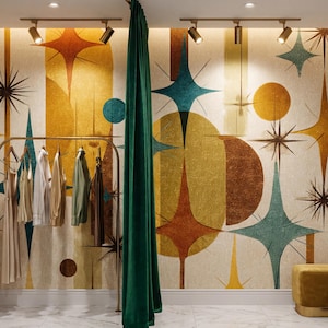 May include: A dressing room featuring a gold clothing rack with hanging garments, a tall gold-framed floor mirror, and a mustard yellow velvet ottoman. The wall is covered in wallpaper with a mid-century starburst pattern in gold, teal, and brown.