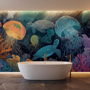 Op de afbeelding: Een badkamer met een witte ovale badkuip. De muur is voorzien van een levendige muurschildering van zeeleven, waaronder kwallen, zeeschildpadden en koraal in tinten oranje, blauw en paars. De vloer is donkergrijze tegels.