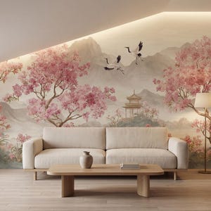May include: A wall mural featuring a landscape with pink cherry blossom trees, two flying cranes, and a pagoda structure set against distant mountains. The scene is rendered in soft, muted tones, providing a backdrop for a beige sofa and coffee table.