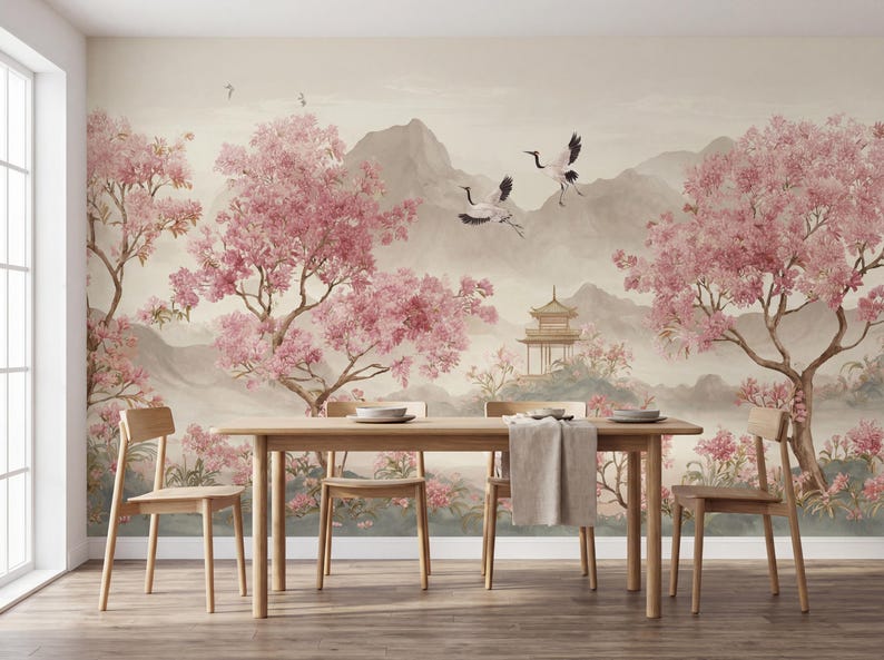 May include: A dining room featuring a wall mural with a landscape of pink cherry blossom trees, flying cranes, and a pagoda set against mountains. A light-toned wooden dining table with four matching chairs sits in front of the wall mural.