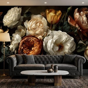 May include: A wall mural featuring a large-scale floral arrangement of white, cream, and deep copper-toned roses and tulips against a dark background, positioned behind a grey tufted sofa, a white oval coffee table, and a tall brass floor lamp.