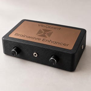 Puede incluir: Un dispositivo electrónico rectangular de color negro con acabado texturizado, que presenta una placa superior de color cobre grabada con el texto VioQuant y Brainwave Enhancer, dos perillas de control negras y un jack central.
