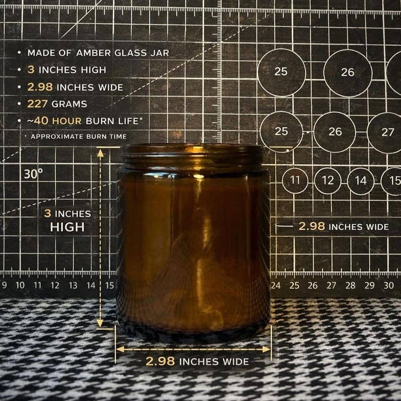 May include: An amber glass candle jar measuring 3 inches high and 2.98 inches wide. The jar weighs 227 grams and features an approximate 40-hour burn life. The text on the image specifies these dimensions and the burn time for the glass container.