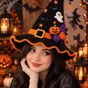 May include: A black crocheted witch hat featuring an orange band with a yellow buckle, decorated with small orange stars, black bats, a white ghost, an orange pumpkin, and purple and orange flowers, with an orange ruffled brim edge.