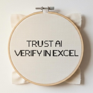 May include: Cross-stitch embroidery in a wooden hoop. The text "TRUST AI VERIFY IN EXCEL" is stitched in black thread on a white fabric. The hoop is secured with a metal screw. The fabric extends slightly beyond the hoop.